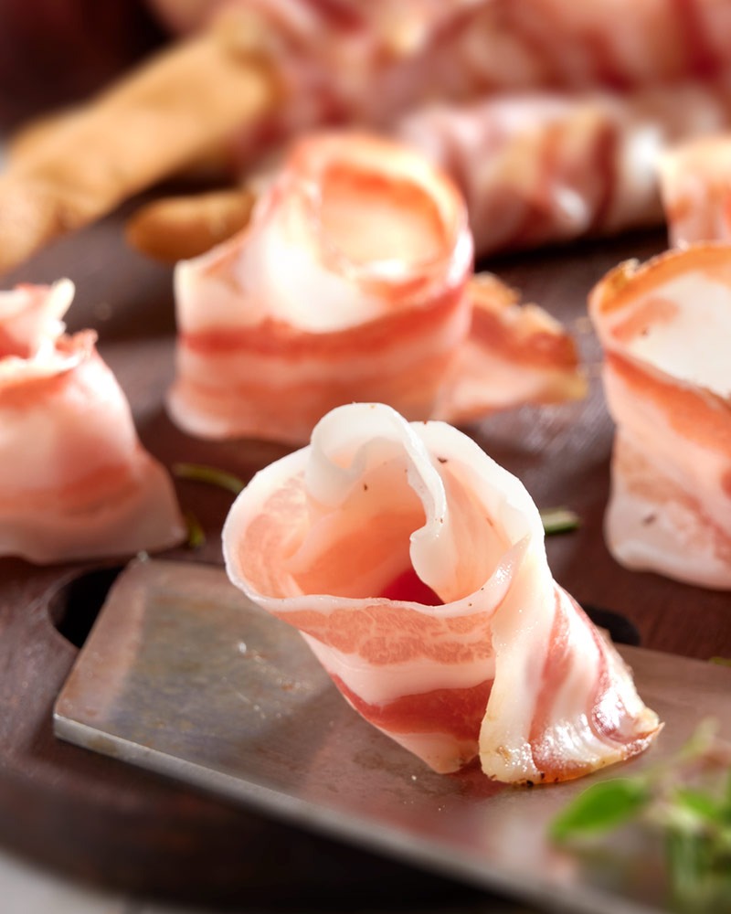 Pancetta vom schwarzen Schwein - Aufschnitt – mit passenden Accessoires arrangiert
